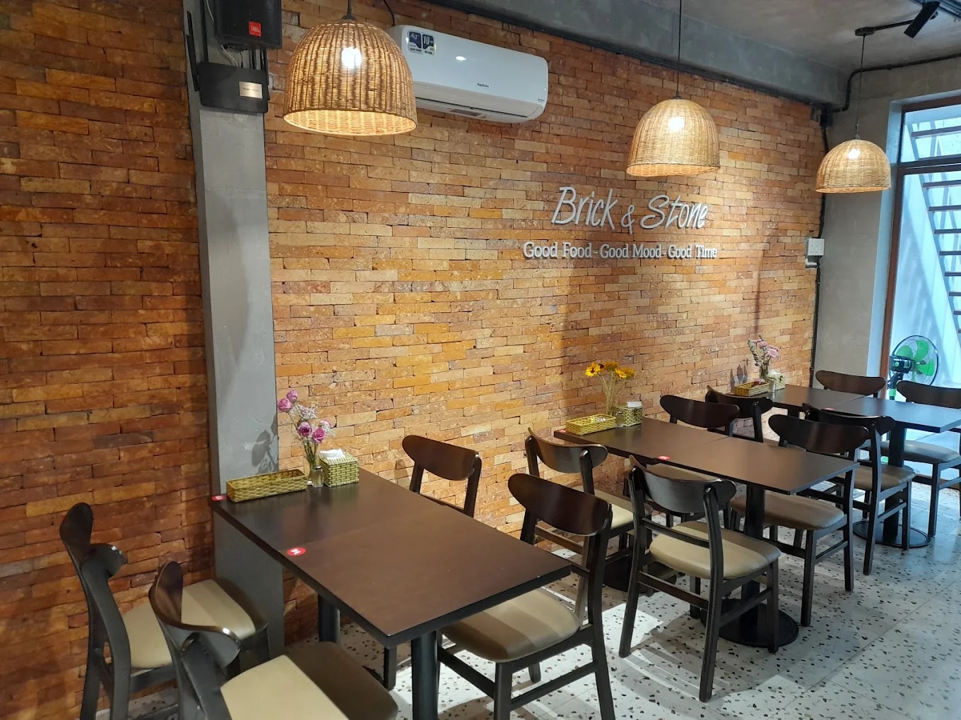 The restaurant features brick walls and wooden tables that bring a rustic yet cozy charm to the dining space